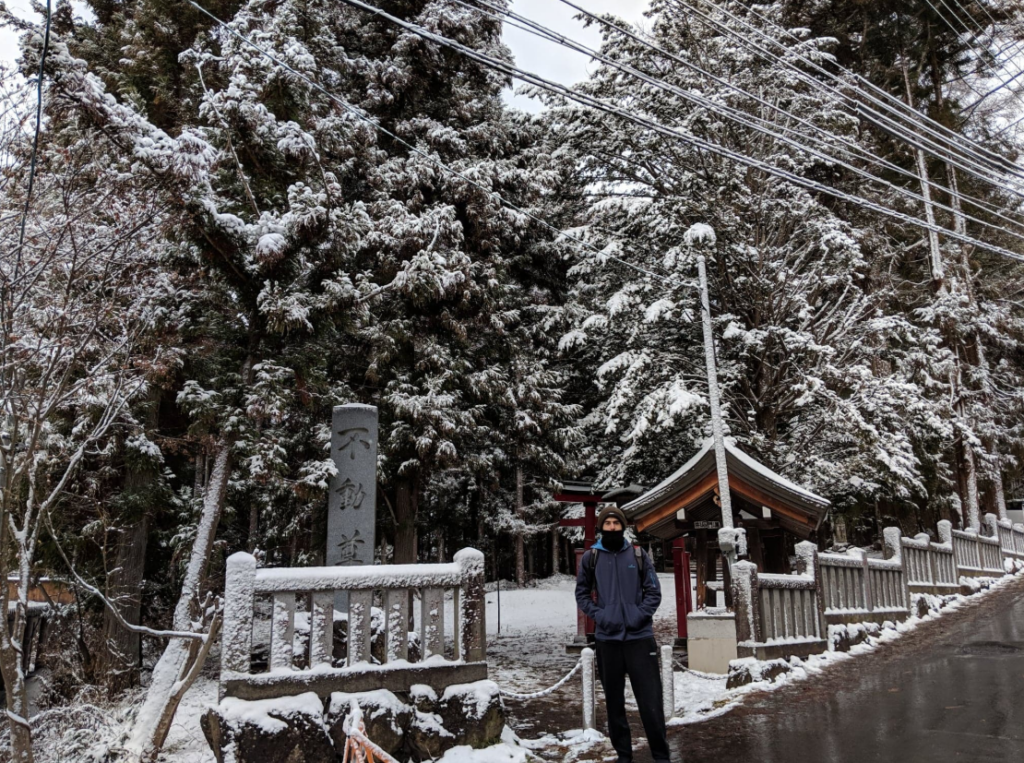 Standing near a shrine at Jigokudani Snow Monkey Park, Nagano.